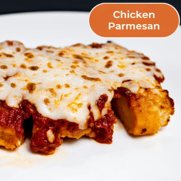 Close-up of a Chicken Parmesan dish with melted cheese and red sauce on a white plate.